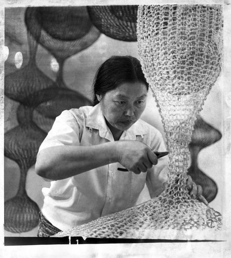 Ruth Asawa working on one of her woven sculptures