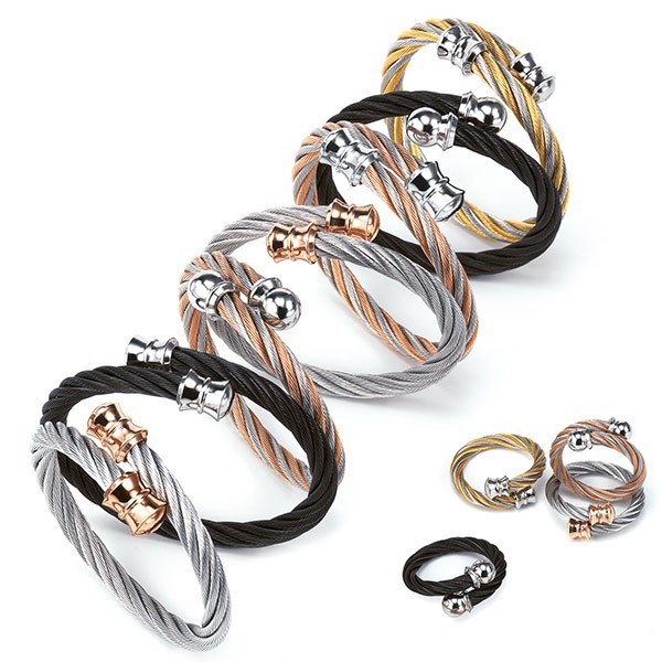 multiple silver, black, and gold cable-like bangles shaped like Celtic torques