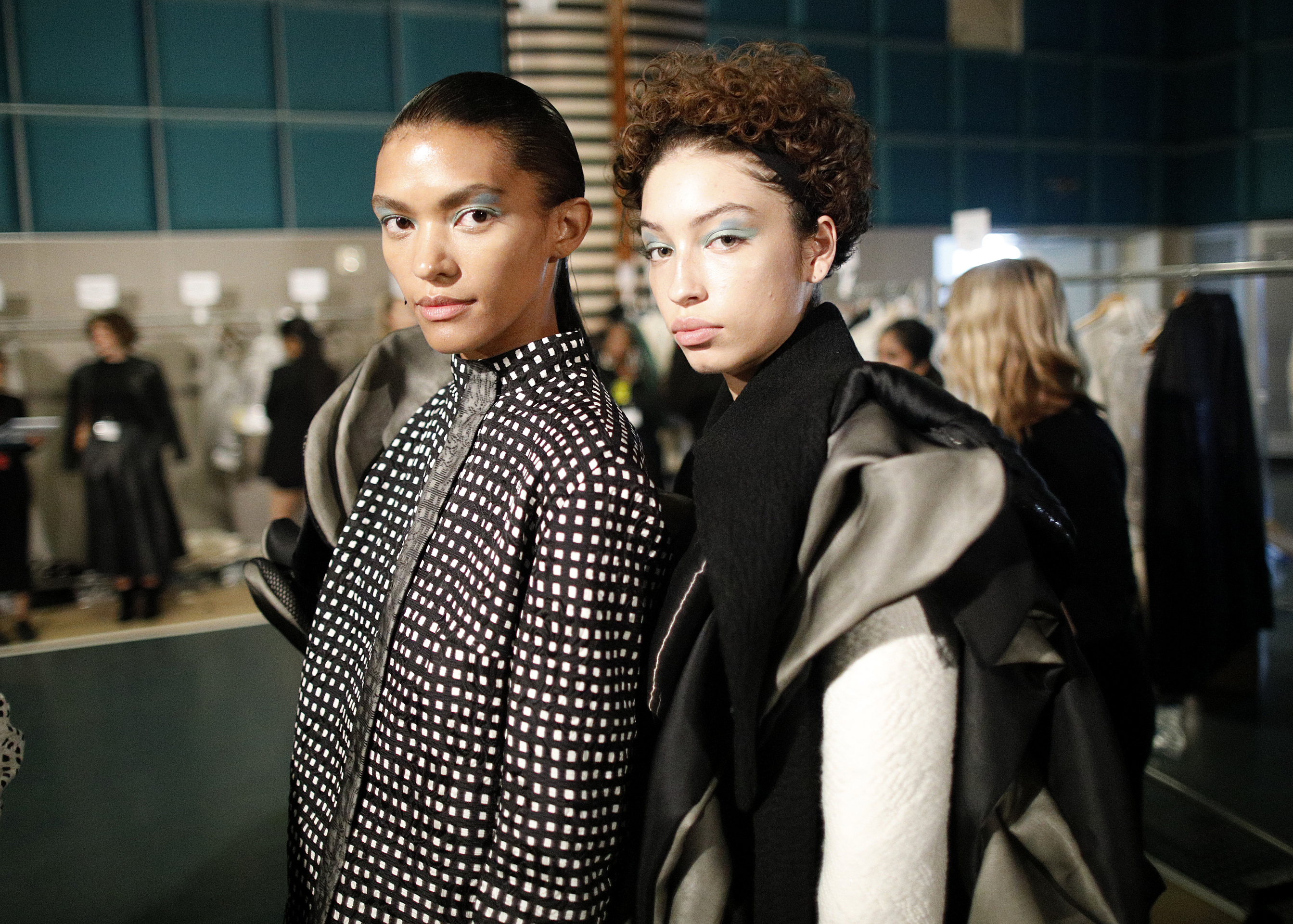 Two models wearing collections by Academy Fashion students gaze at camera