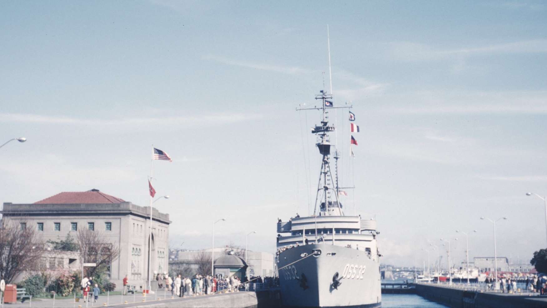 US Navy Destroyer docked next to a brick building.